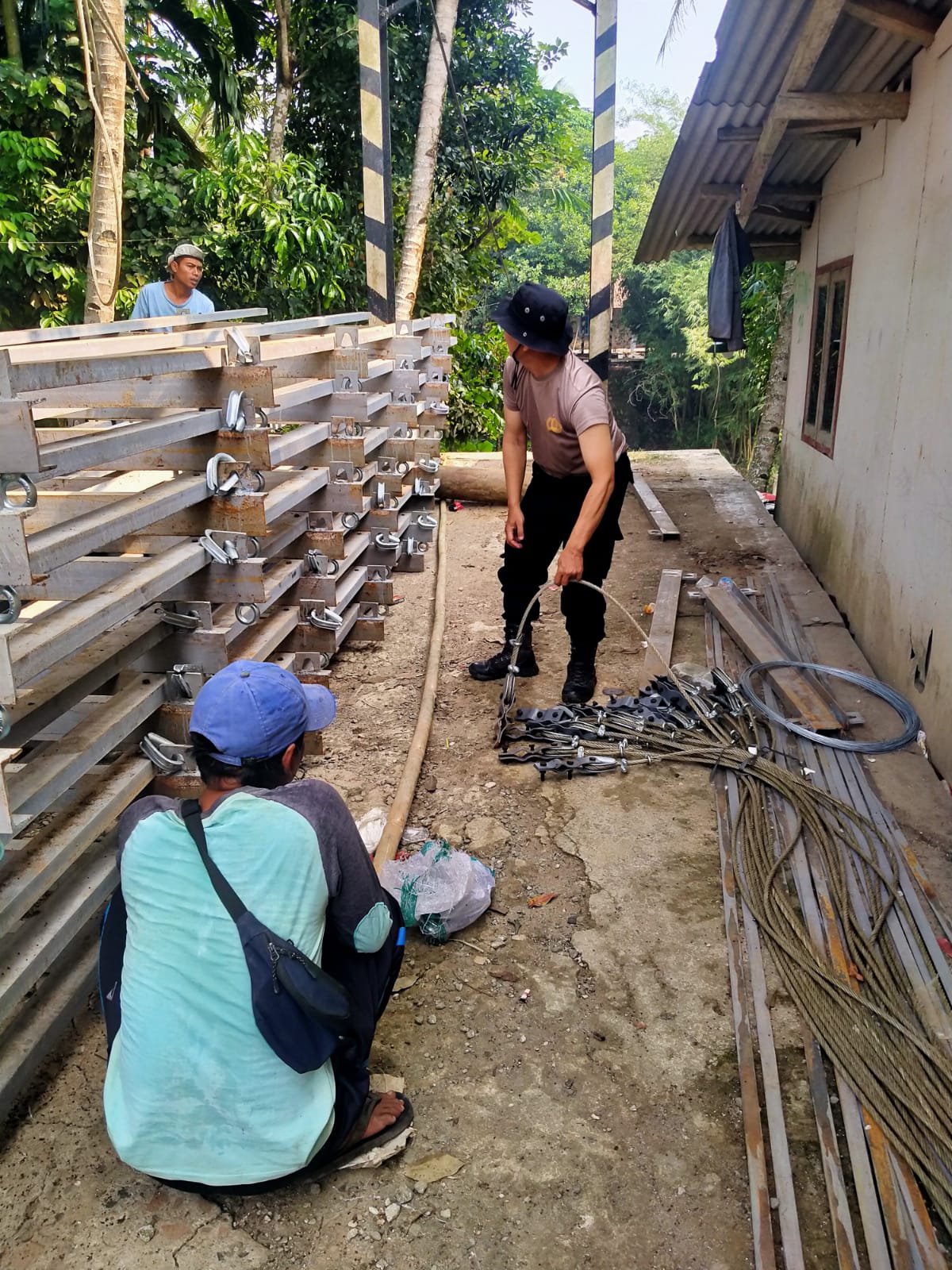 Pastikan Pekerjaan Berjalan Lancar Dan Aman, Kapolsek Cimarga Polres Lebak Gotong Royong Jembatan Merah Putih Di Kampung Parung Lampung Desa Intenjaya Cimarga.